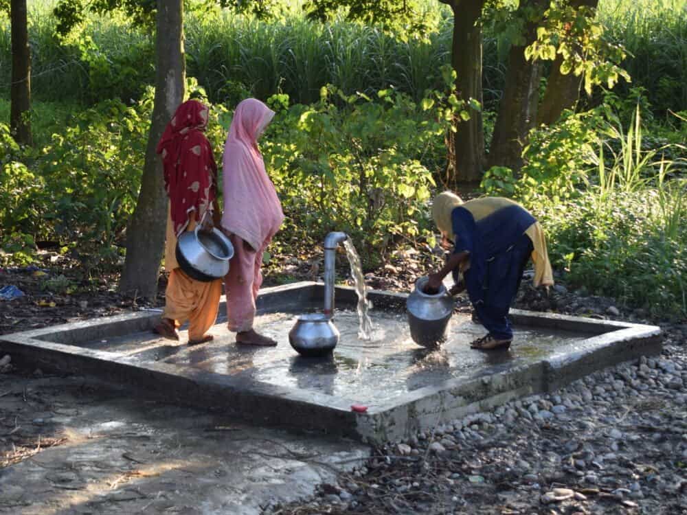 Frauen am Wasserbrunnen eines Dorfes in Indien