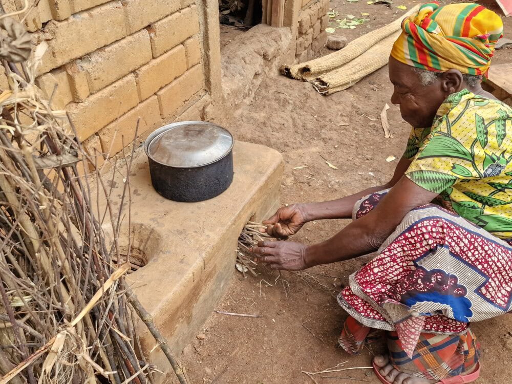 Uganda: Ältere Frau for Energiesparofen