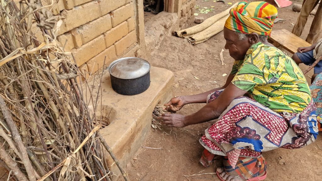 Uganda: Ältere Frau for Energiesparofen